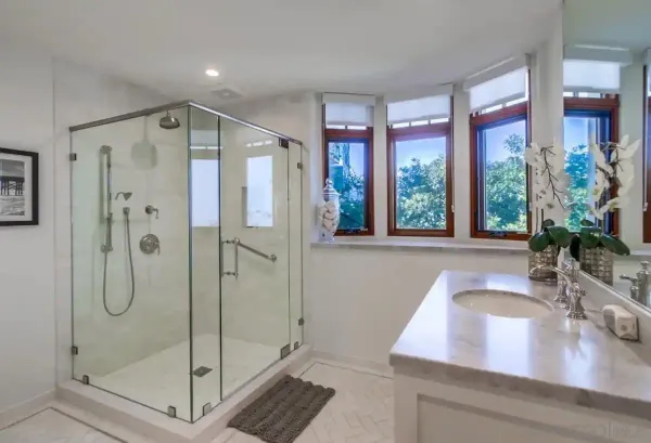 a bathroom with a granite countertop sink a toilet and shower