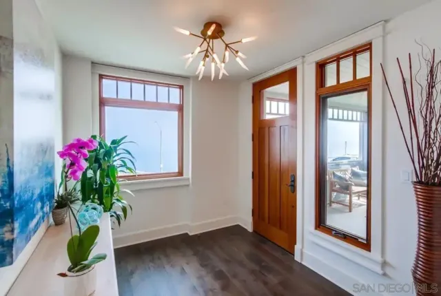 a vase of flowers sitting on a floor next to a window