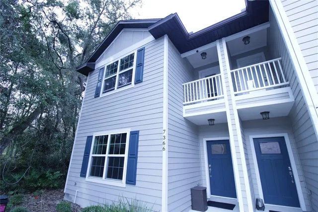 a view of a house with a large window and wooden fence