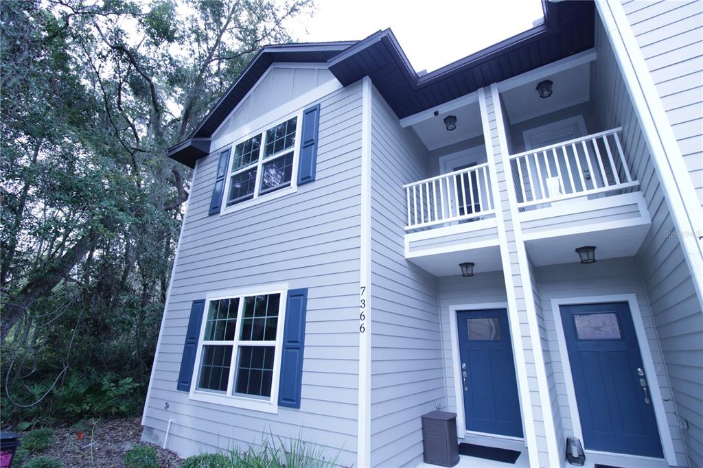 a view of a house with a large window and wooden fence