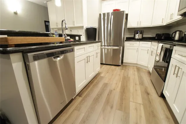 a kitchen with stainless steel appliances a refrigerator stove and sink