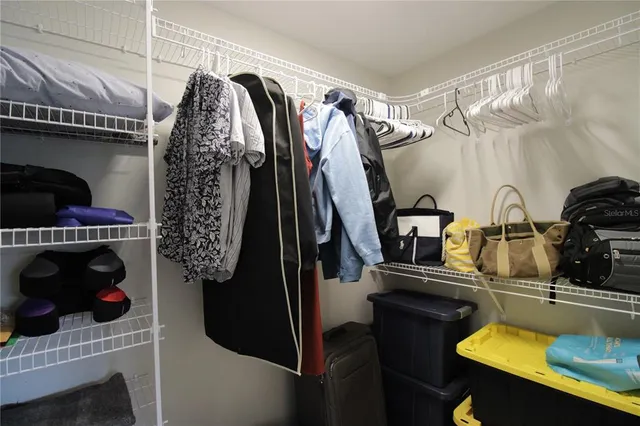 a view of walk in closet with clothes and shoes
