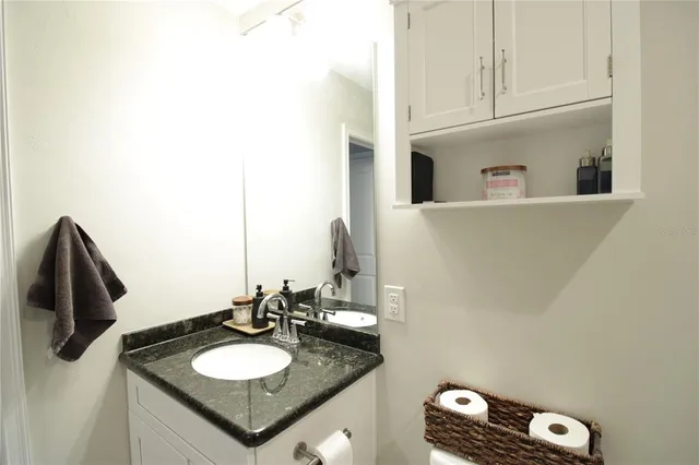 a bathroom with a granite countertop sink and a mirror