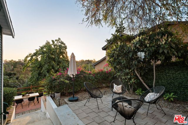 a backyard of a house with table and chairs potted plants