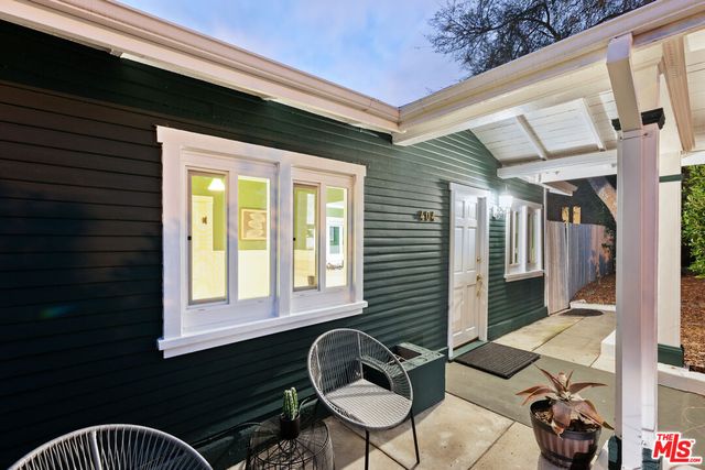 front view of house with a yard and large trees