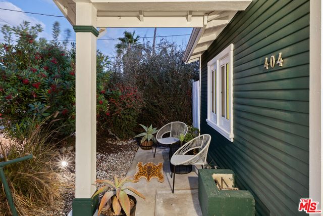 a front view of a house with a yard and potted plants