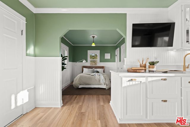 a bedroom with a bed and wooden floor