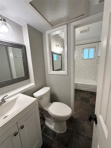 a bathroom with a toilet a sink and mirror