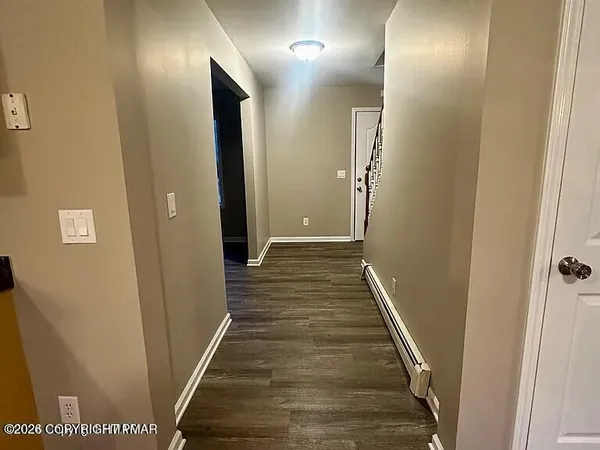 a view of a hallway with wooden floor
