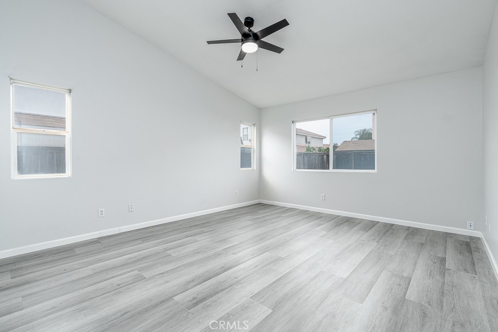 4680 Birchleaf Lane Hemet, CA 92545 - Photo 11 of 34 an empty room with wooden floor ceiling fan and windows