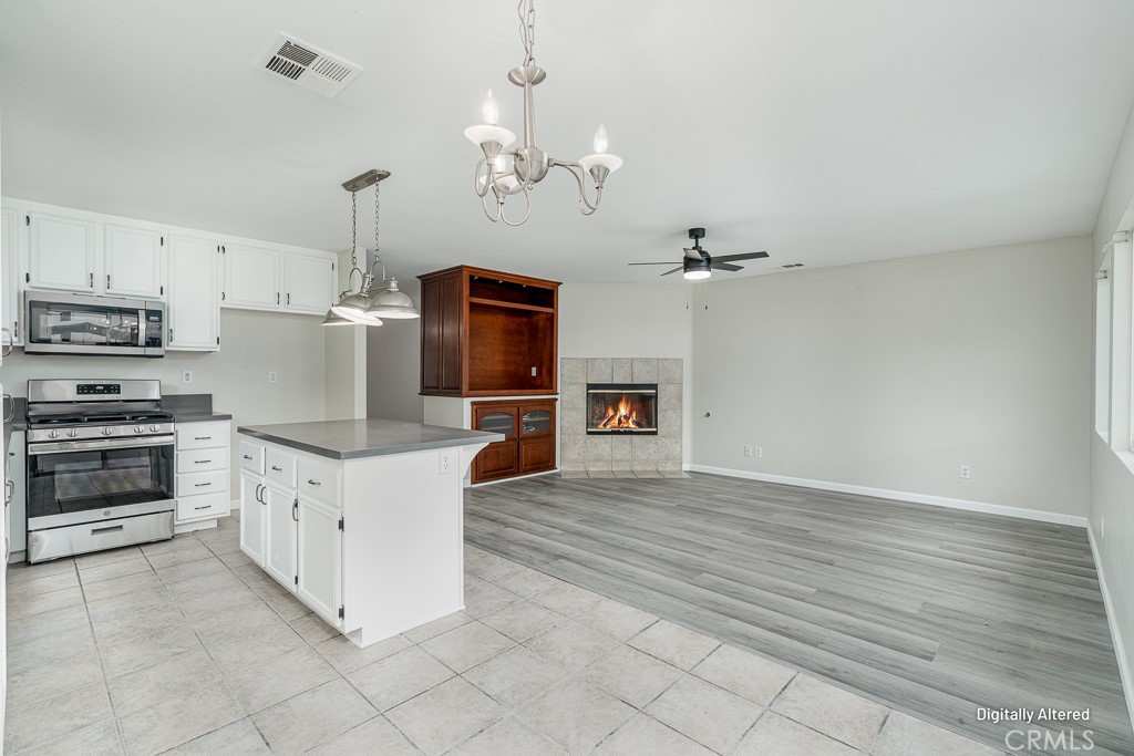 4680 Birchleaf Lane Hemet, CA 92545 - Photo 8 of 34 a kitchen with kitchen island a stove a sink and a refrigerator