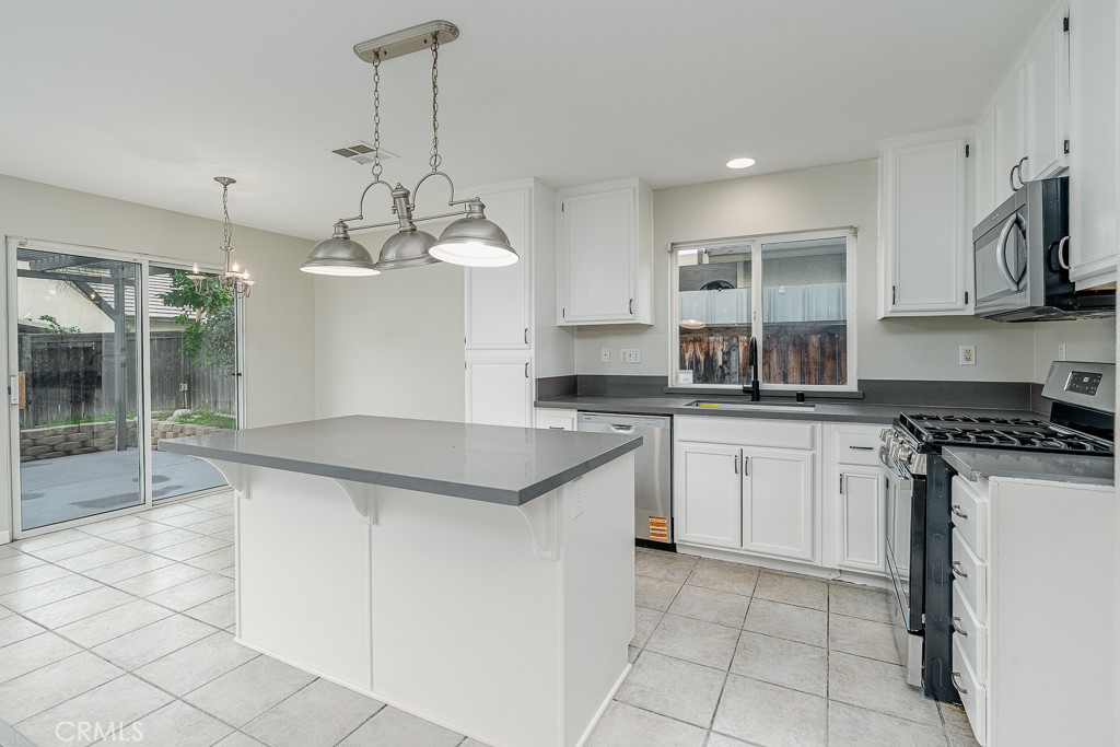 4680 Birchleaf Lane Hemet, CA 92545 - Photo 9 of 34 a kitchen with stainless steel appliances granite countertop a sink and a stove