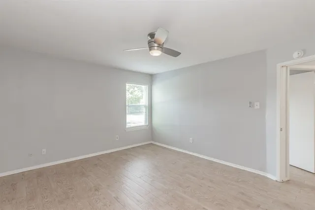 a view of an empty room and a ceiling fan window