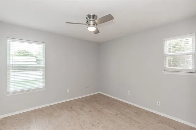 a view of a room with a ceiling fan and a window