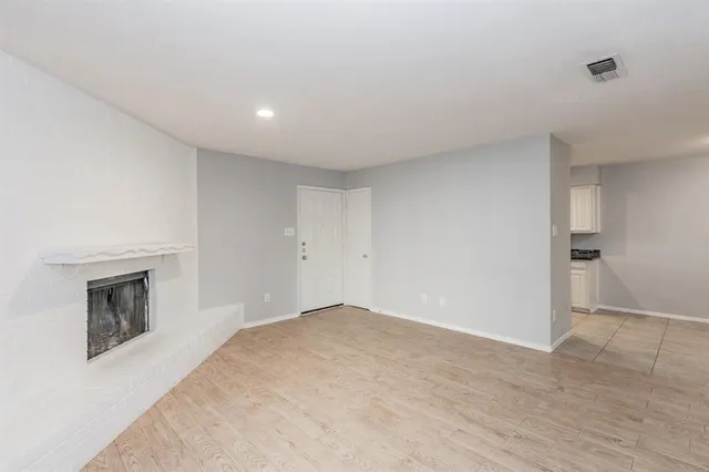 a view of empty room with a fireplace and cabinet