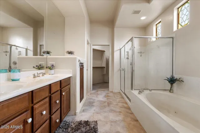 a bathroom with a tub a sink a mirror and a shower