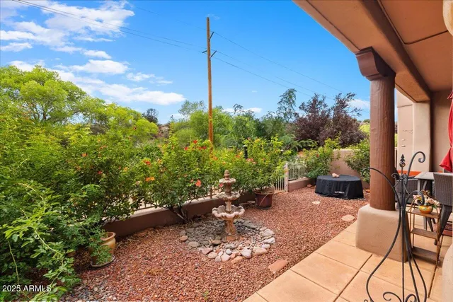 a backyard of a house with table and chairs potted plants