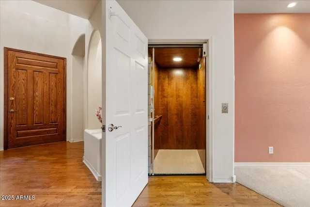 a view of a hallway with wooden floor and closet