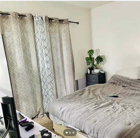 a bedroom with a bed and a potted plant