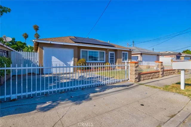 a view of a house with a small yard and wooden fence