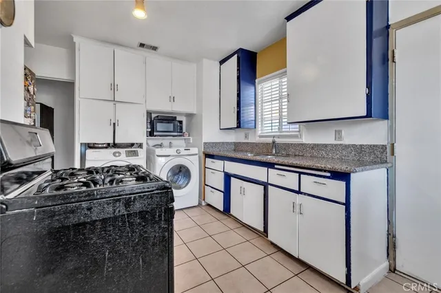 a kitchen with granite countertop a sink stove and cabinets