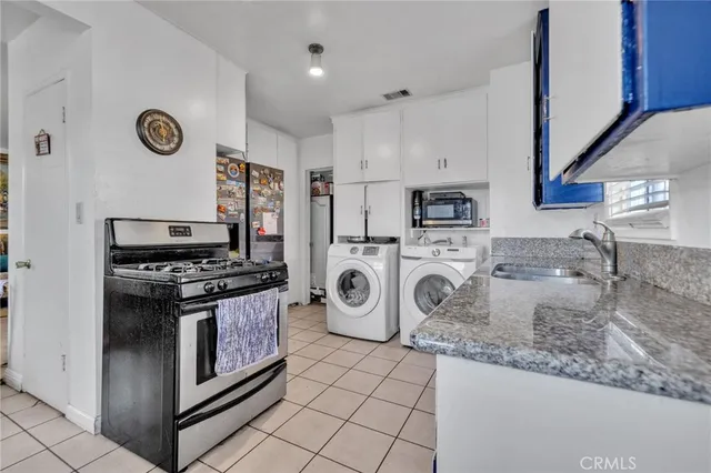 a kitchen with granite countertop a sink stove and cabinets