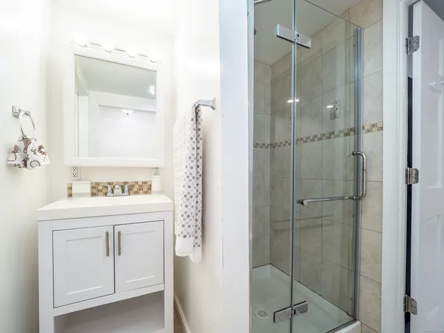 a bathroom with a shower sink and mirror