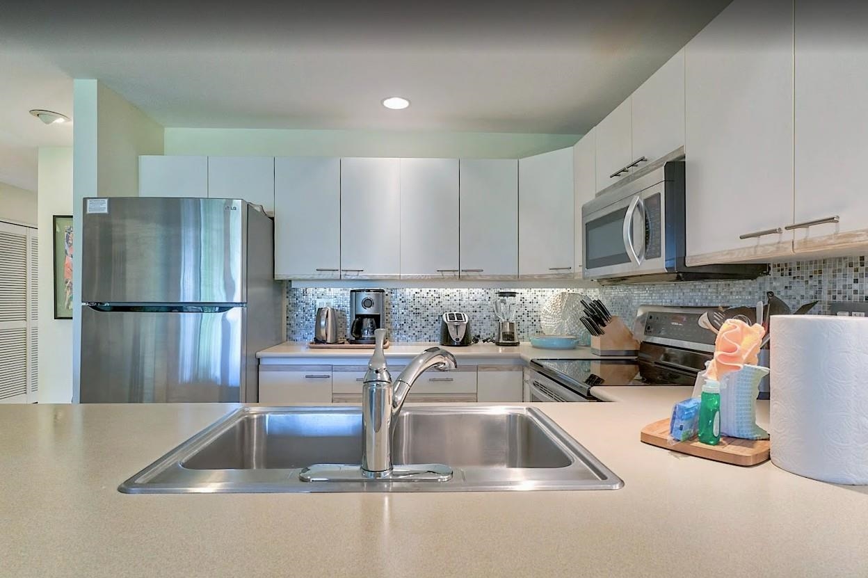 2777 South Kihei Road, Unit D109 Kihei, HI 96753 - Photo 9 of 50 a kitchen with stainless steel appliances granite countertop a refrigerator and a sink