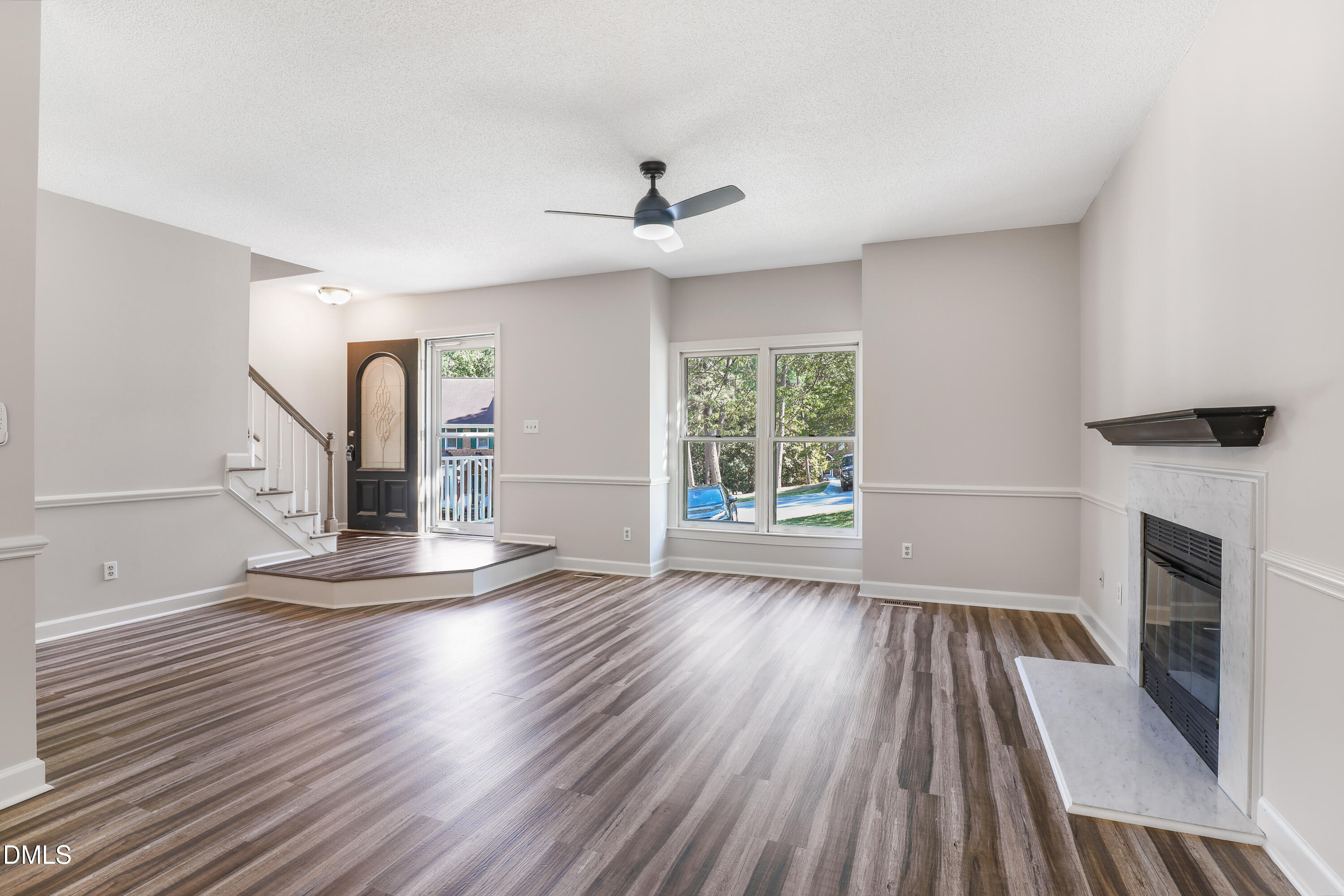 15 Preakness Drive Durham, NC 27713 - Photo 3 of 32 an empty room with wooden floor fireplace and windows