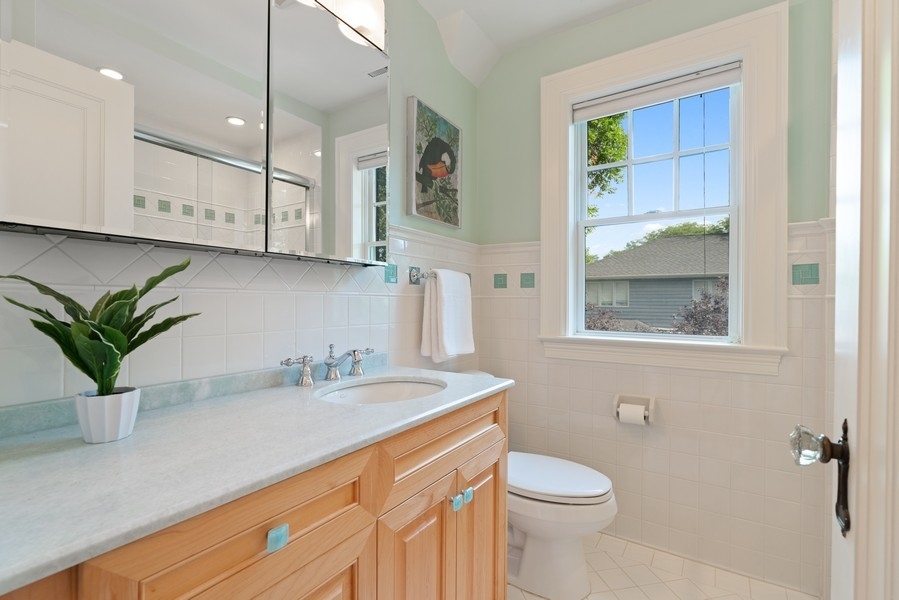 727 Indian Road Glenview, IL 60025 - Photo 29 of 58 a bathroom with a sink a toilet and a mirror