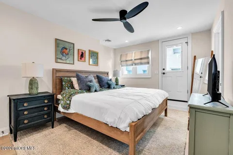 a bedroom with a bed and a flat tv screen on dresser