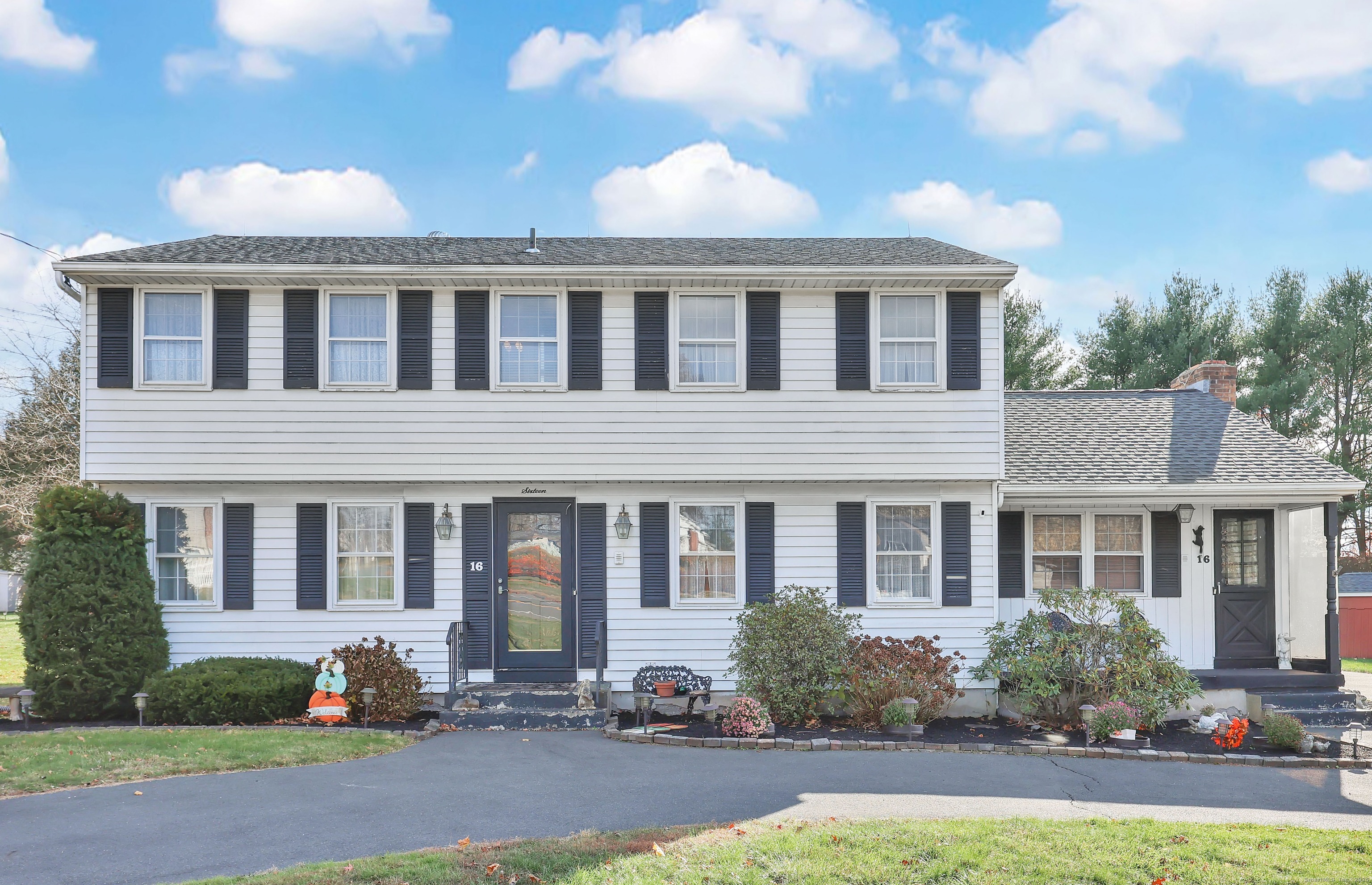 a front view of house with yard and trees in the background