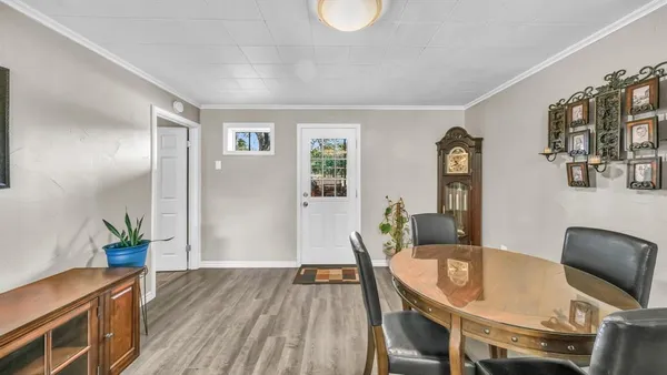 a kitchen with stainless steel appliances granite countertop a stove top oven a sink dishwasher a dining table and chairs with wooden floor