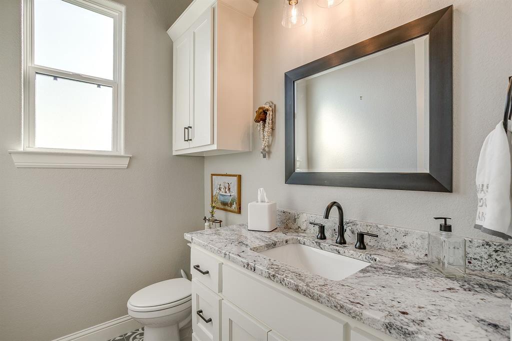 116 Aviara Ridge Road Poolville, TX 76487 - Photo 24 of 38 a bathroom with a granite countertop toilet sink and mirror
