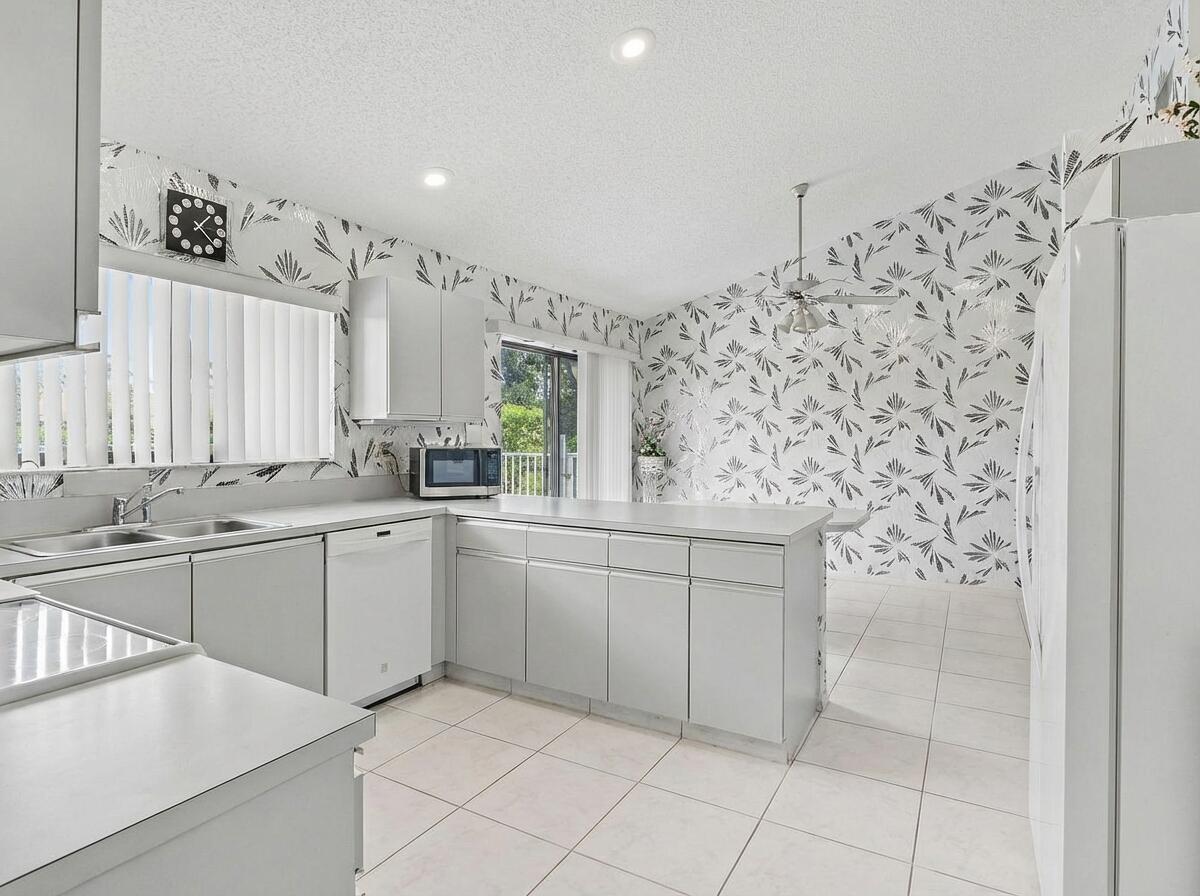 9476 El Clair Ranch Road Boynton Beach, FL 33437 - Photo 15 of 28 a kitchen with stainless steel appliances a sink and cabinets