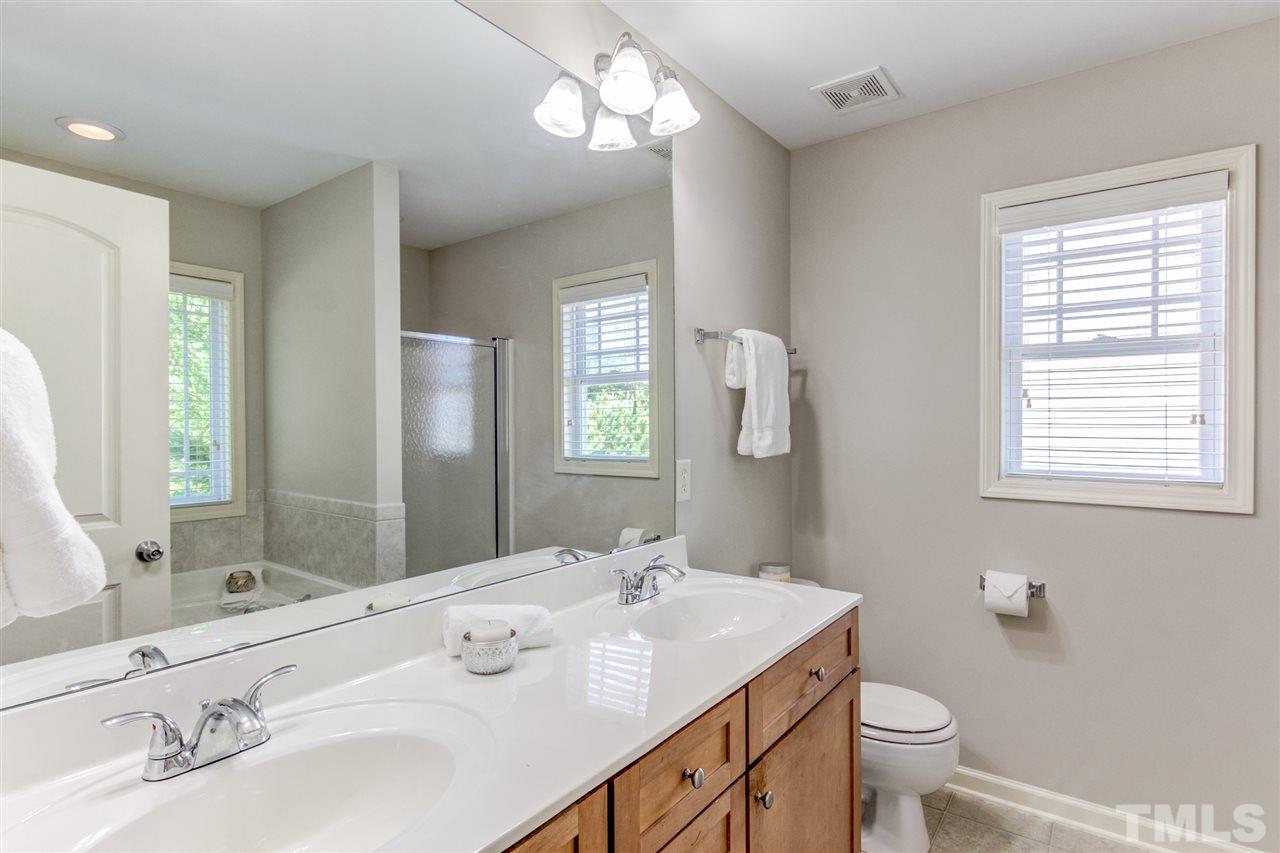 4143 White Kestrel Drive Raleigh, NC 27616 - Photo 16 of 30 a bathroom with a granite countertop double vanity sink a mirror and a toilet