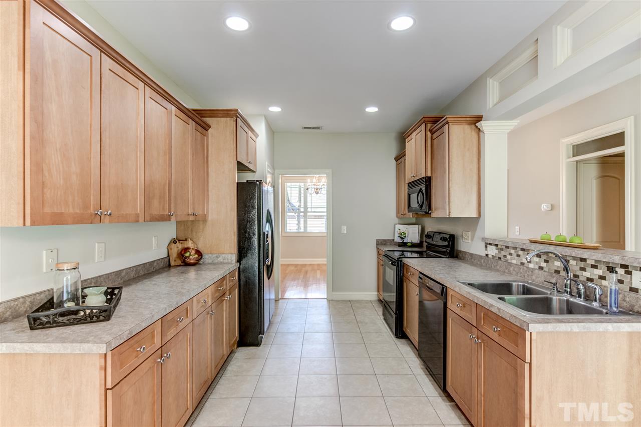 4143 White Kestrel Drive Raleigh, NC 27616 - Photo 6 of 30 a kitchen with a sink stove top oven and cabinets
