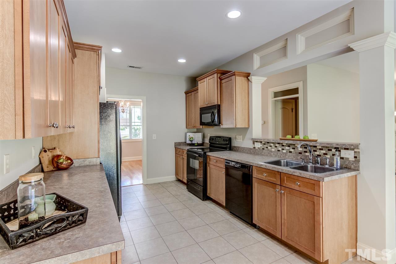 4143 White Kestrel Drive Raleigh, NC 27616 - Photo 7 of 30 a large kitchen with stainless steel appliances granite countertop a stove and a sink