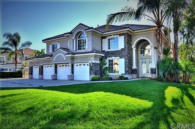 a front view of a house with a garden and yard