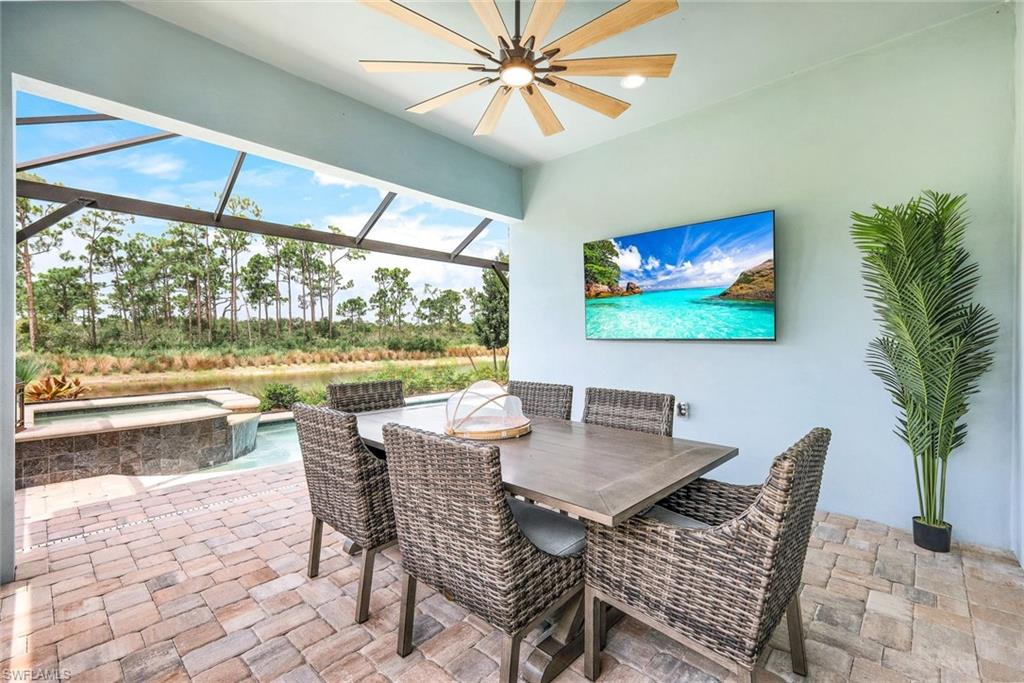 6875 Saona Court Naples, FL 34113 - Photo 14 of 21 a dining room with furniture a large window and a rug