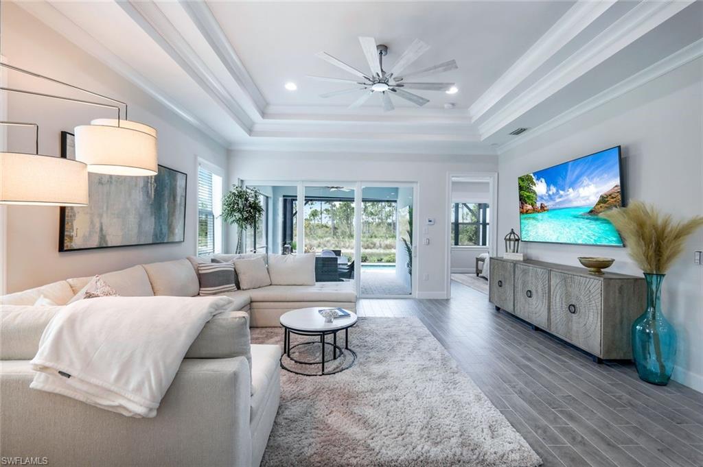 6875 Saona Court Naples, FL 34113 - Photo 2 of 21 a living room with furniture a flat screen tv and a large window