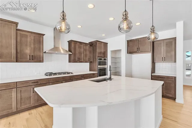 a kitchen with stainless steel appliances a table and chairs in it