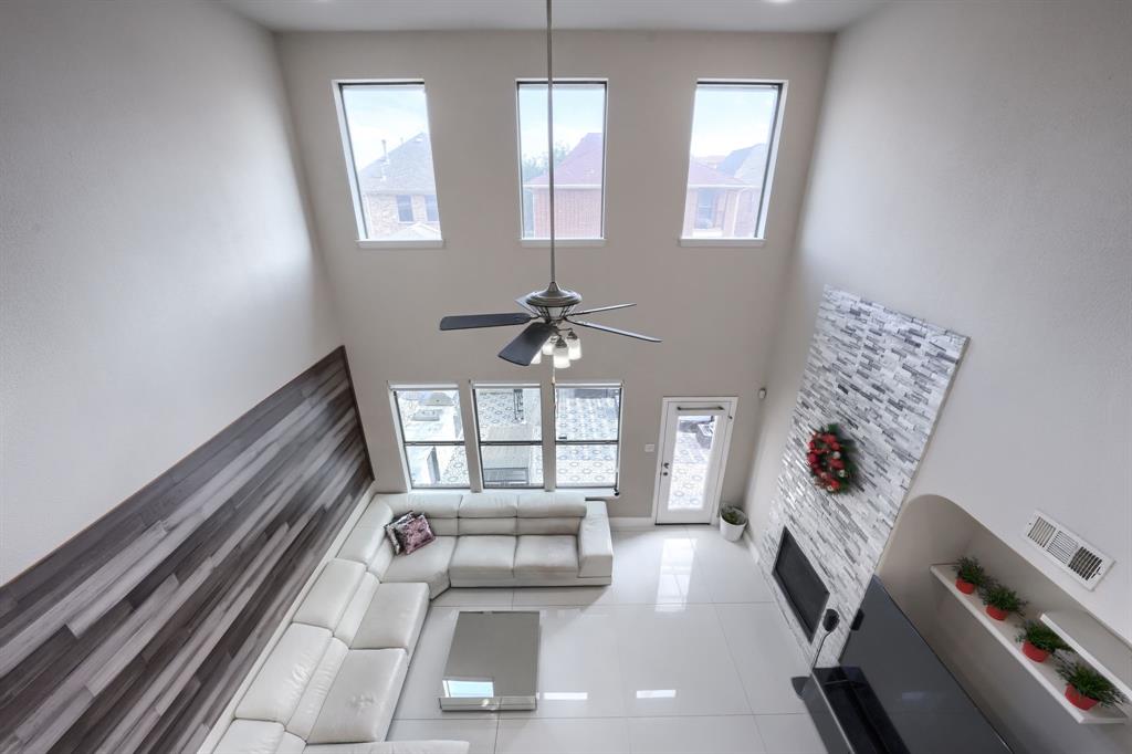 2246 Longview Road Irving, TX 75063 - Photo 27 of 40 Soaring vaulted ceiling featuring a modern ceiling fan and multiple high windows