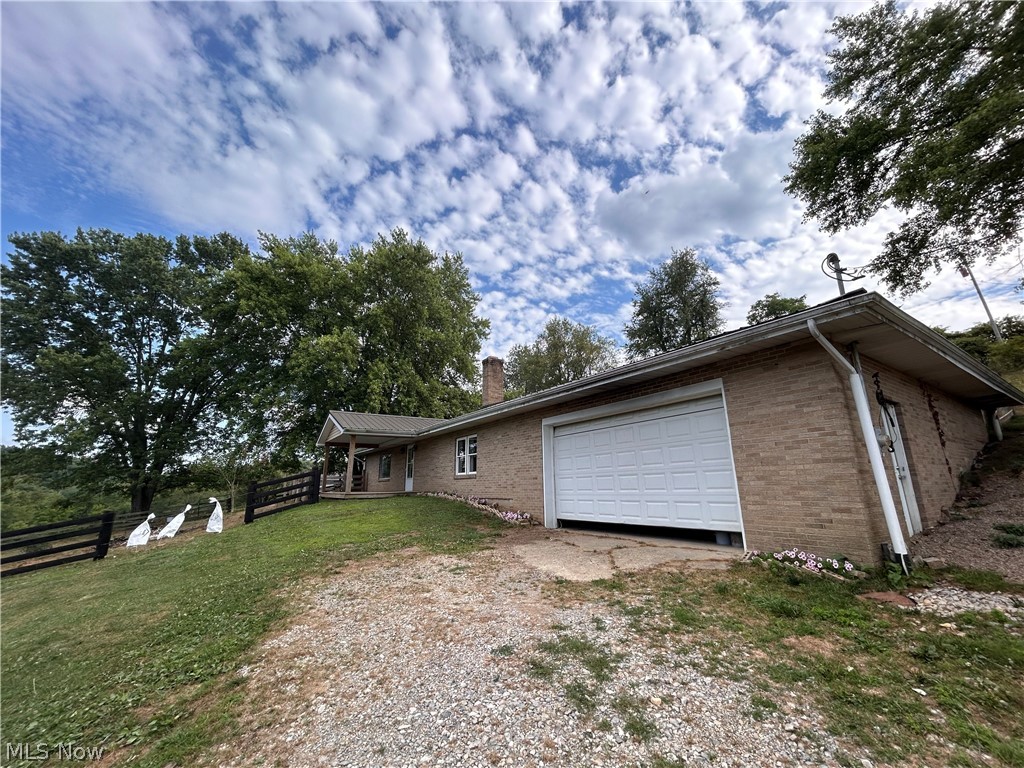 78600 Freeport Tippecanoe Road Freeport, OH 43973 - Photo 23 of 37 View of side of property featuring a garage and a yard