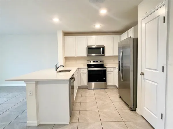 a kitchen with stainless steel appliances a refrigerator sink and microwave
