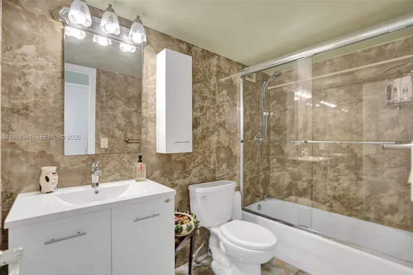a bathroom with a sink mirror toilet and bathtub