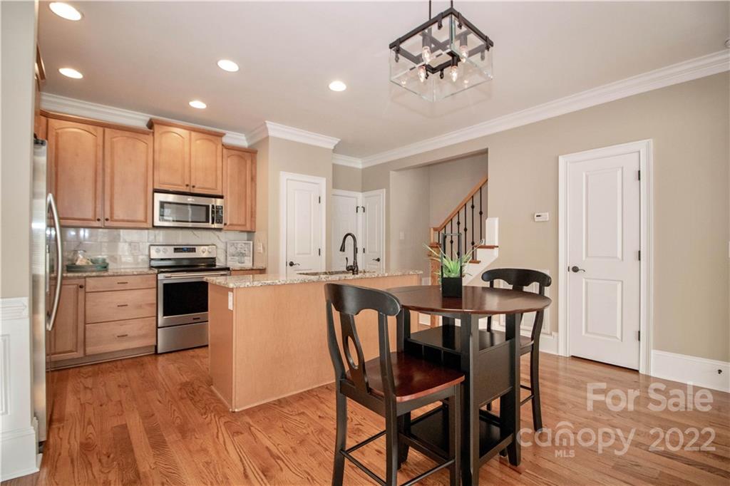 333 Spring Street Davidson, NC 28036 - Photo 11 of 44 a kitchen with a table chairs microwave and refrigerator