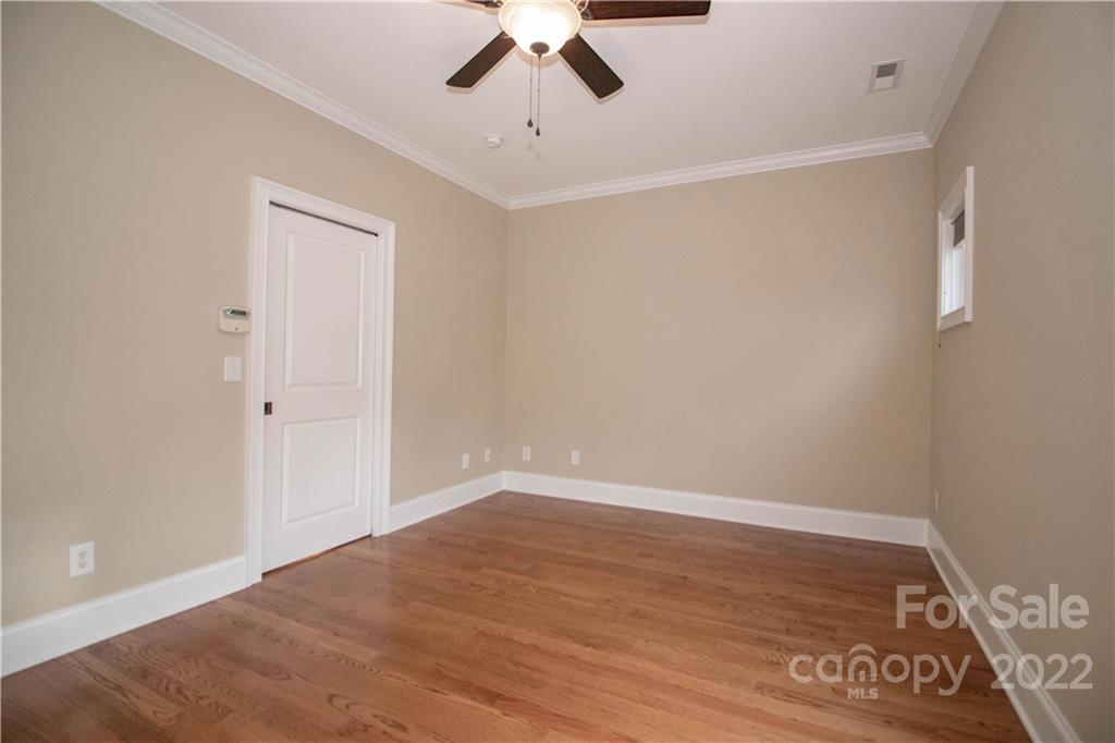 333 Spring Street Davidson, NC 28036 - Photo 23 of 44 an empty room with a ceiling fan and wooden floor