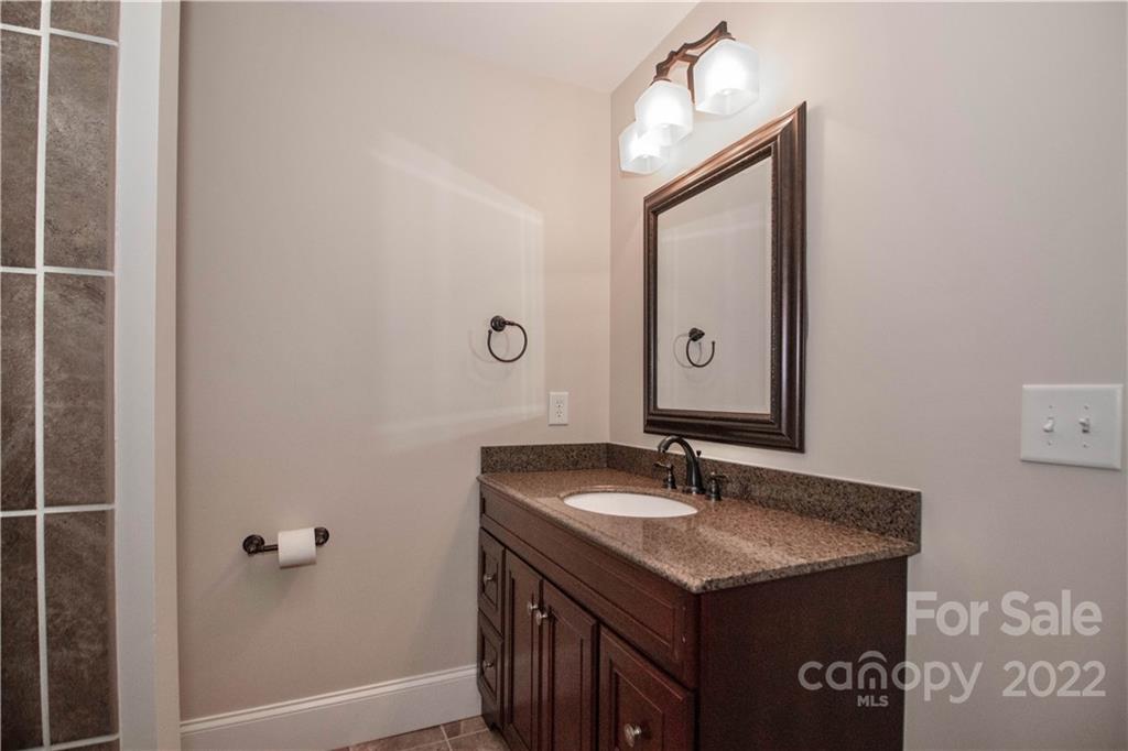 333 Spring Street Davidson, NC 28036 - Photo 36 of 44 a bathroom with a granite countertop sink and a mirror