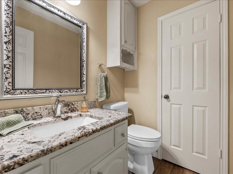 1072 Chapman Road Crawford, TX 76638 - Photo 23 of 39 a bathroom with a granite countertop toilet sink and mirror